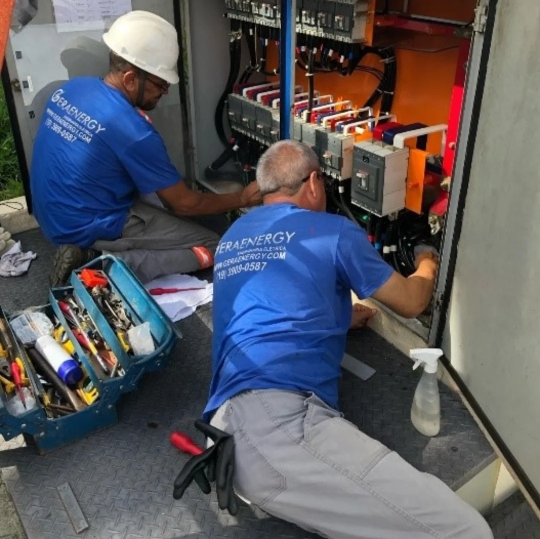 Dois técnicos uniformizados da Geraenergy executando serviço em quadro de distribuição