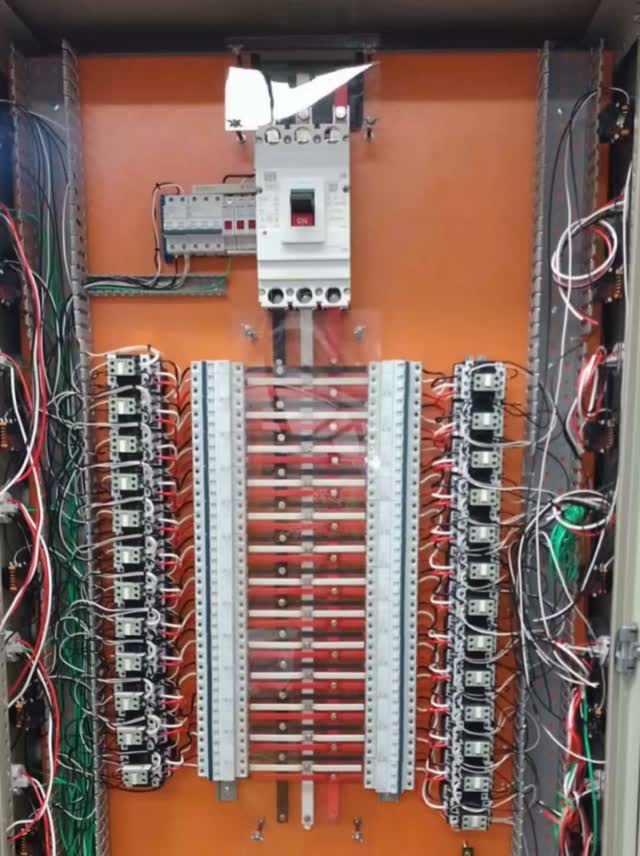 Painel elétrico aberto mostrando disjuntor em caixa moldada, relés, disjuntores em trilho DIN e barramento de cobre